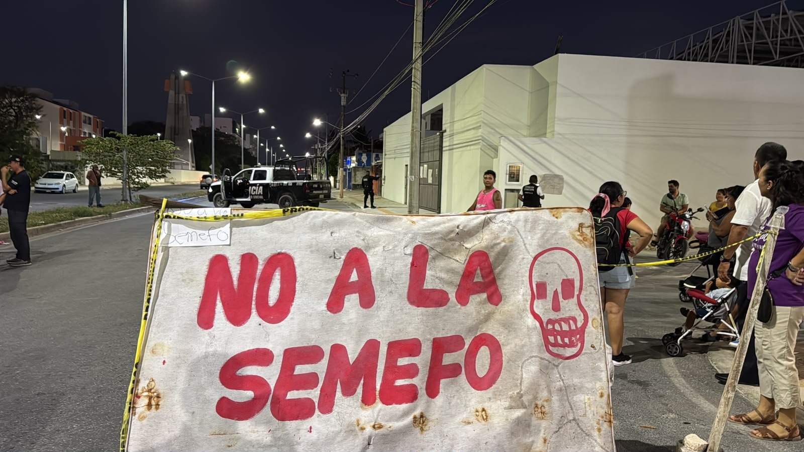 Residents block Avenida Politécnico in Cancún with branches and rocks to protest a forensic medical service facility