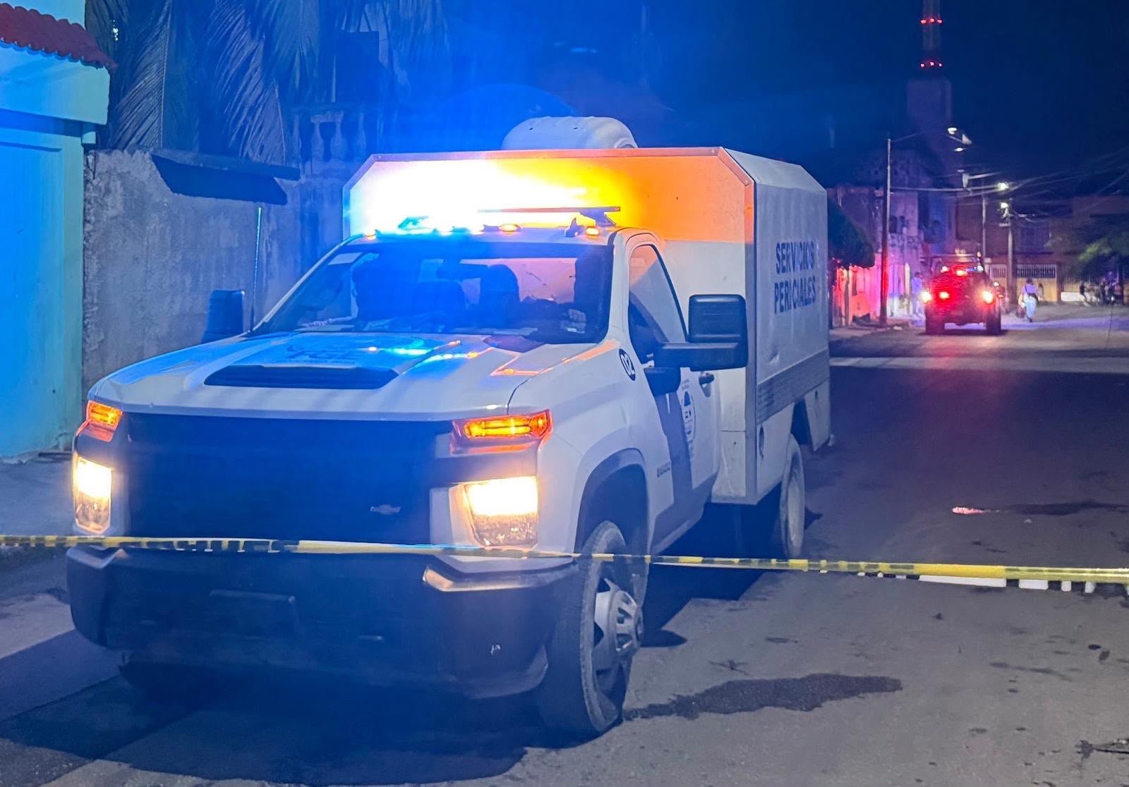 Police officers at the scene of a shooting in Cancun, with a red Chevrolet showing bullet impacts