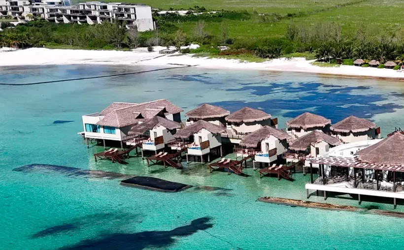 Aerial view of a hotel structure extending over the turquoise waters of Laguna Bojórquez in Cancun's hotel zone