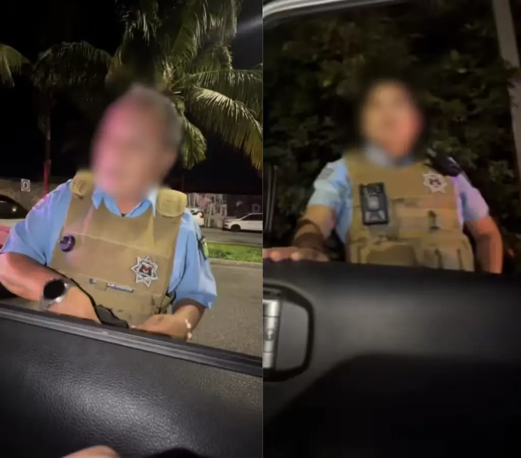 Two Cancun tourist police officers standing by a patrol car in the hotel zone