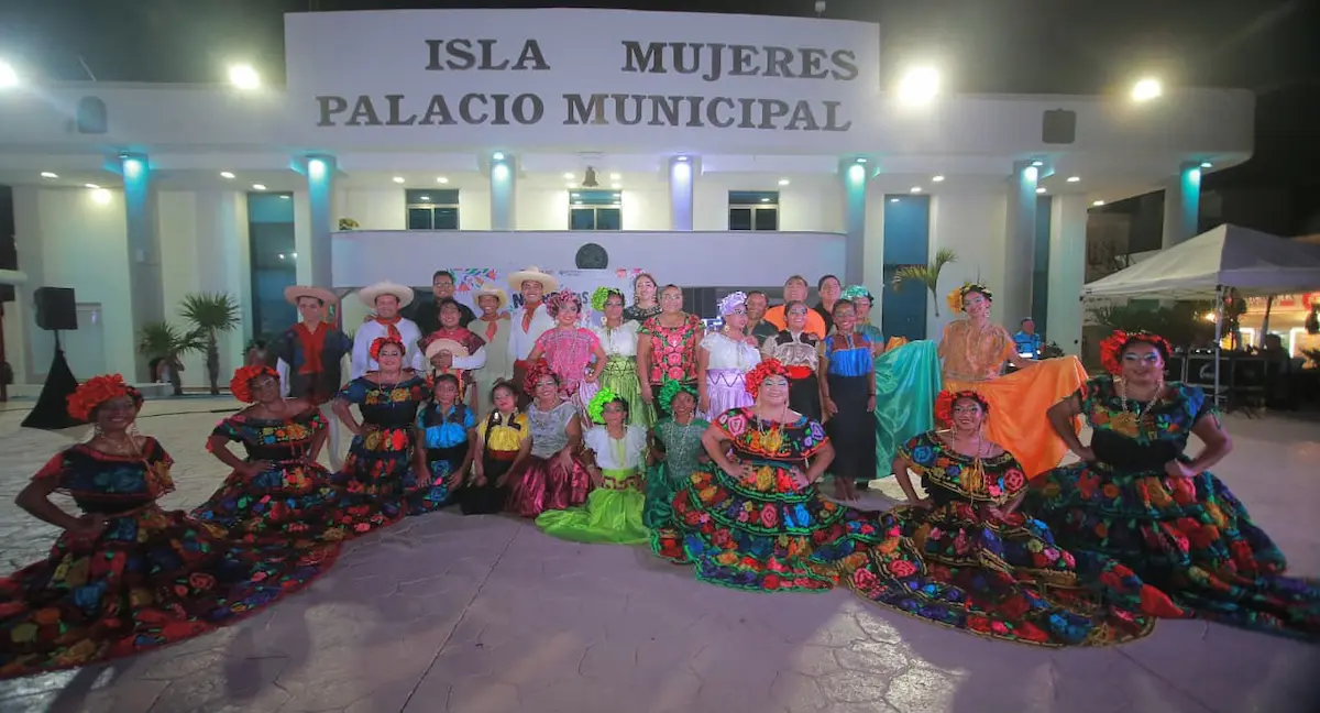 Dancers in colorful traditional costumes perform on stage at the municipal esplanade in Isla Mujeres.