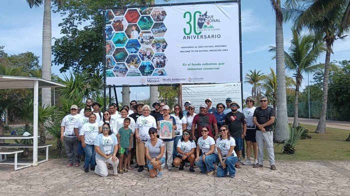 People gather at Cenote Aerolito for the opening event of Cozumel Reefs National Park's 30th anniversary celebrations