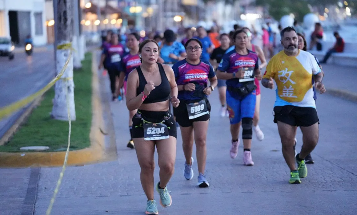 Runners participating in the Cozumel Night Half Marathon on the island's streets at night
