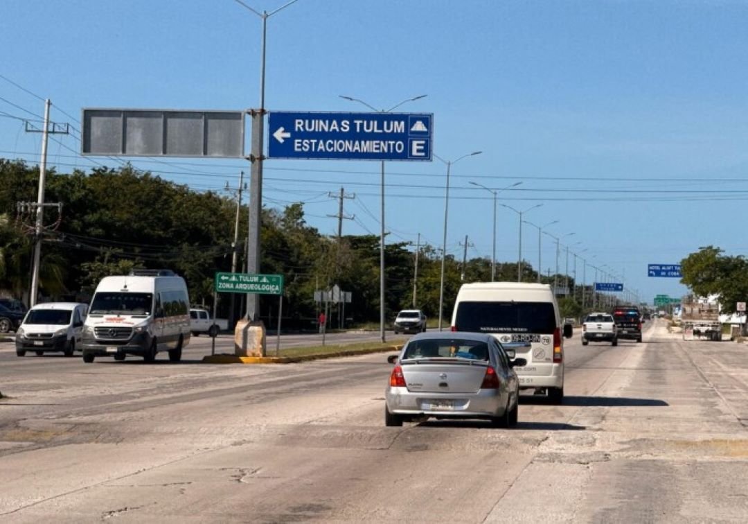 A red Chevrolet Aveo and a white Mercedes-Benz Sprinter van involved in a collision on a highway in Quintana Roo.