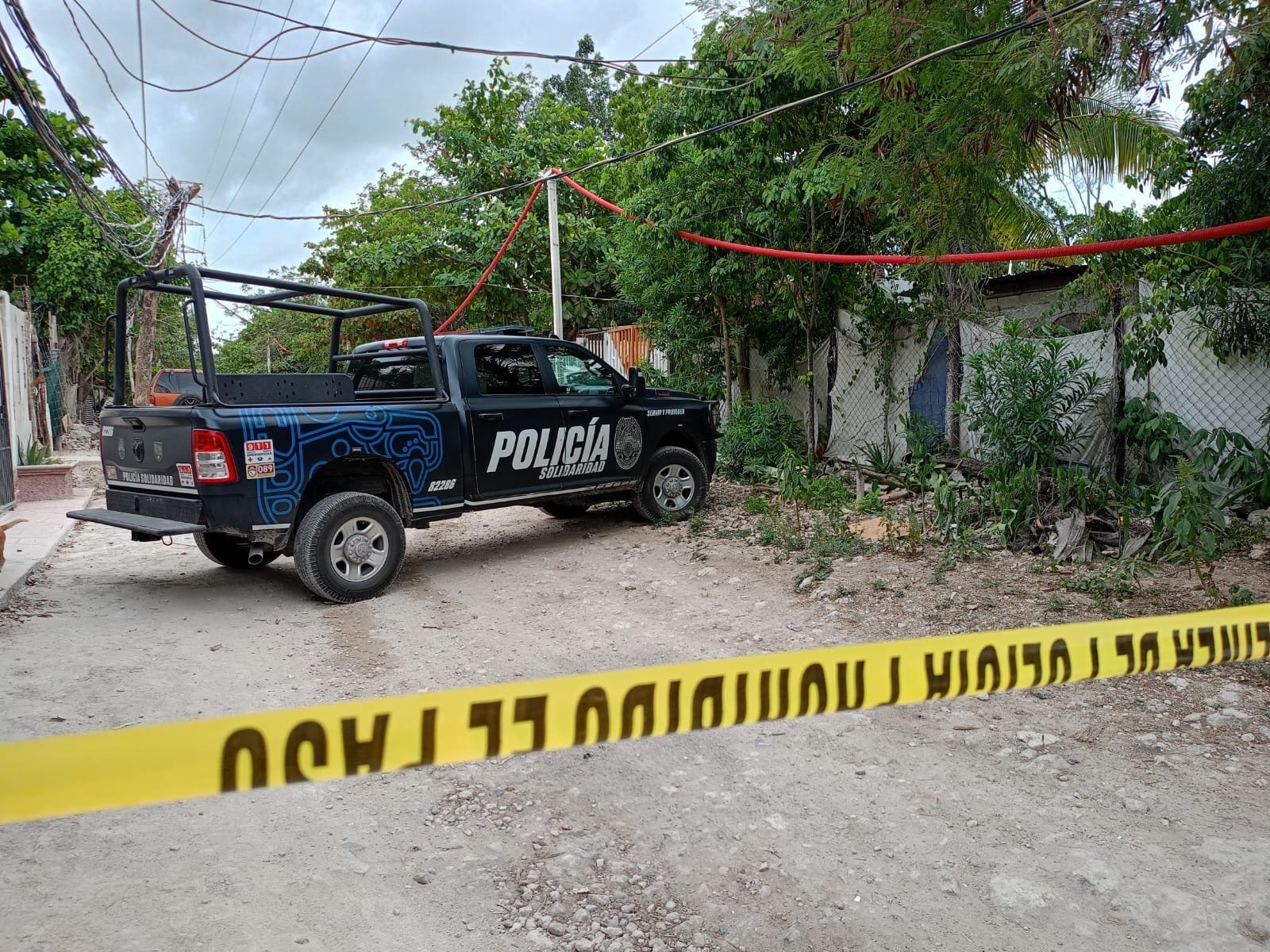 Police tape cordoning off a dirt road in Las Torres neighborhood after a shooting