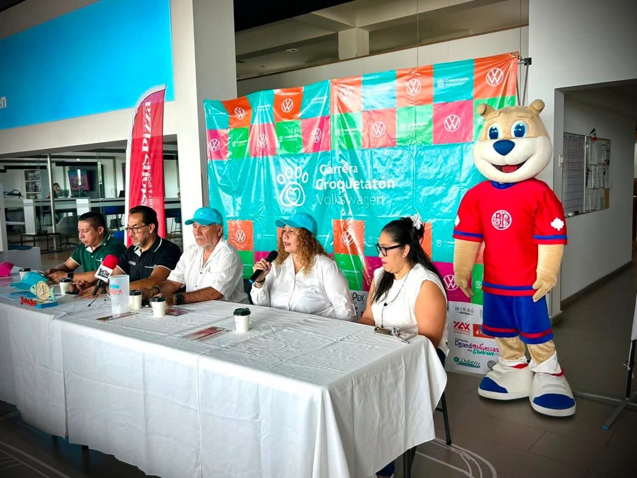 Participants running with dogs at Croquetatón charity event in Cancún