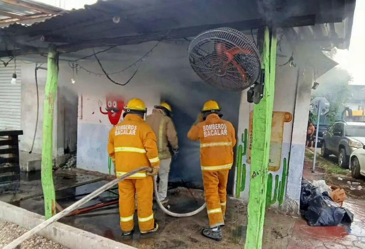 Firefighters extinguish flames at a taco restaurant in Bacalar, Quintana Roo