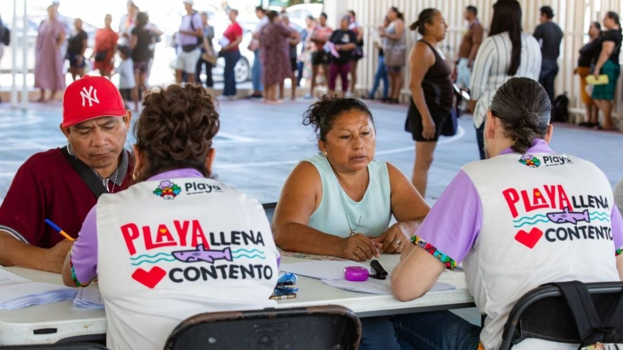People receiving food packages at a community center in Puerto Aventuras