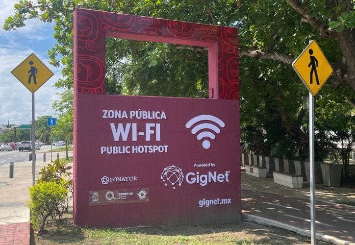 A person using a laptop in a public park with free WiFi in Quintana Roo