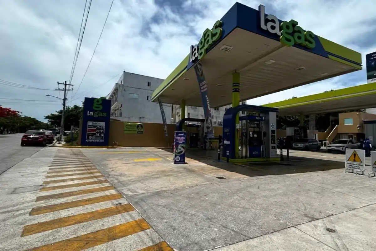 A gas station in Cancún displaying fuel prices, with cars at the pumps.