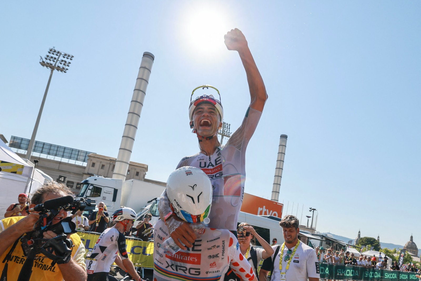 Isaac Del Toro crossing the finish line with arms raised during Stage 2 of the Tour de France