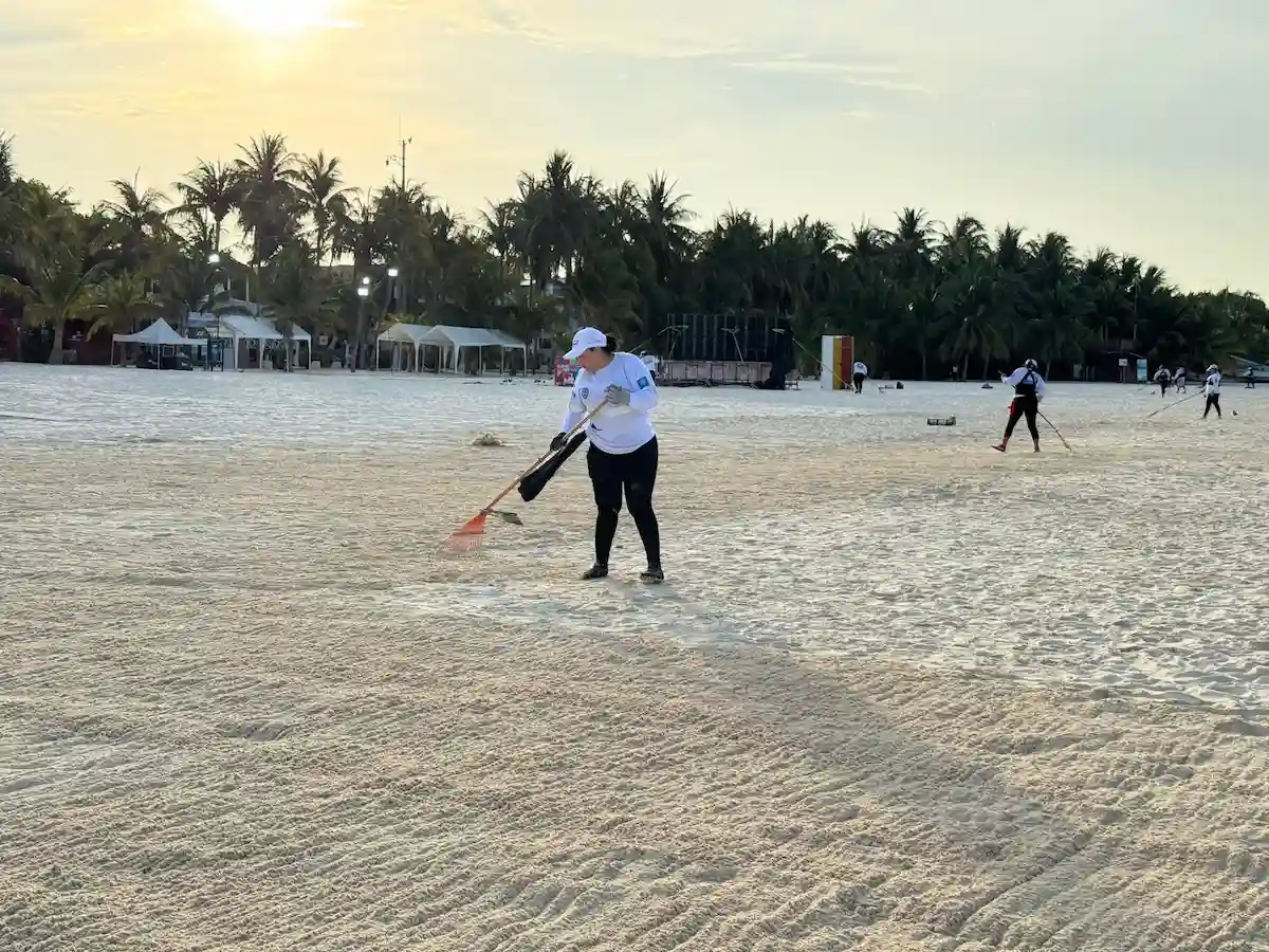 Workers cleaning sargassum from a beach in Isla Mujeres, Quintana Roo