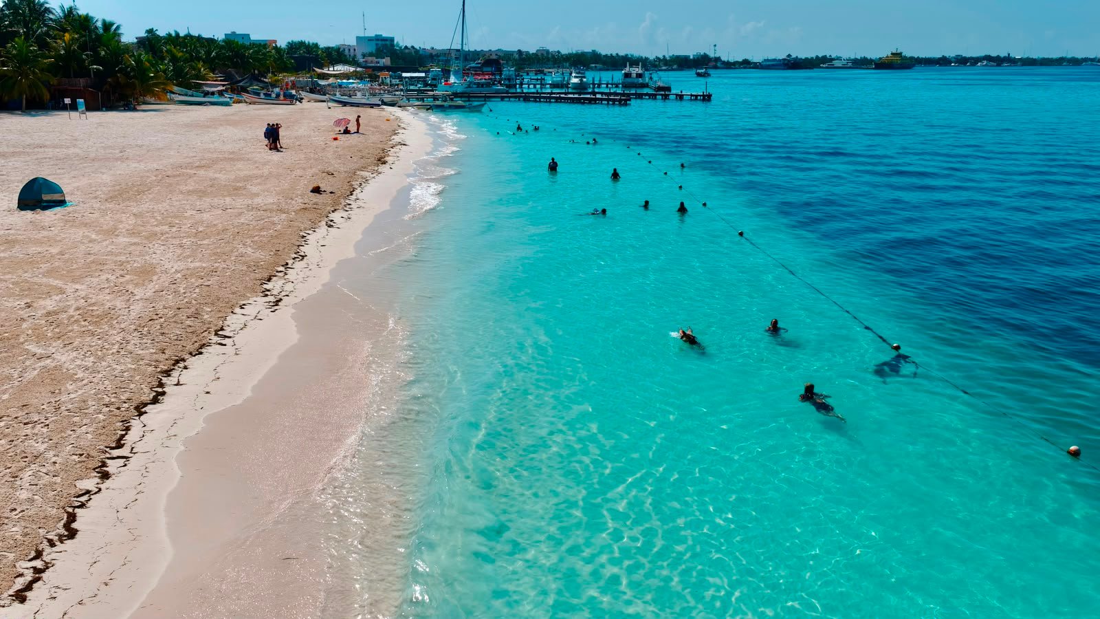 Aerial view of Playa Norte in Isla Mujeres with clear turquoise water and Blue Flag flying