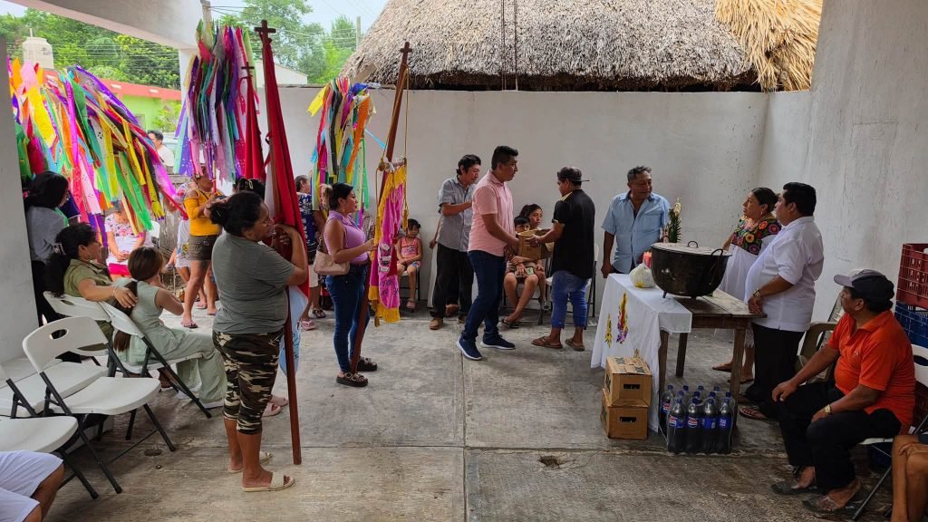 Community members participate in a procession with colorful banners during the Santa Ana guild celebration in Tihosuco, Quintana Roo.