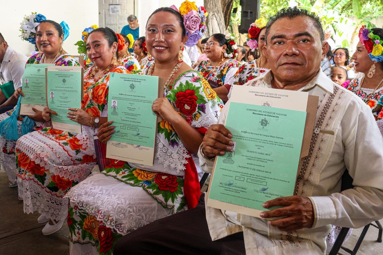 Graduates in traditional Yucatecan attire at the Maya language interpreter certification ceremony in Merida