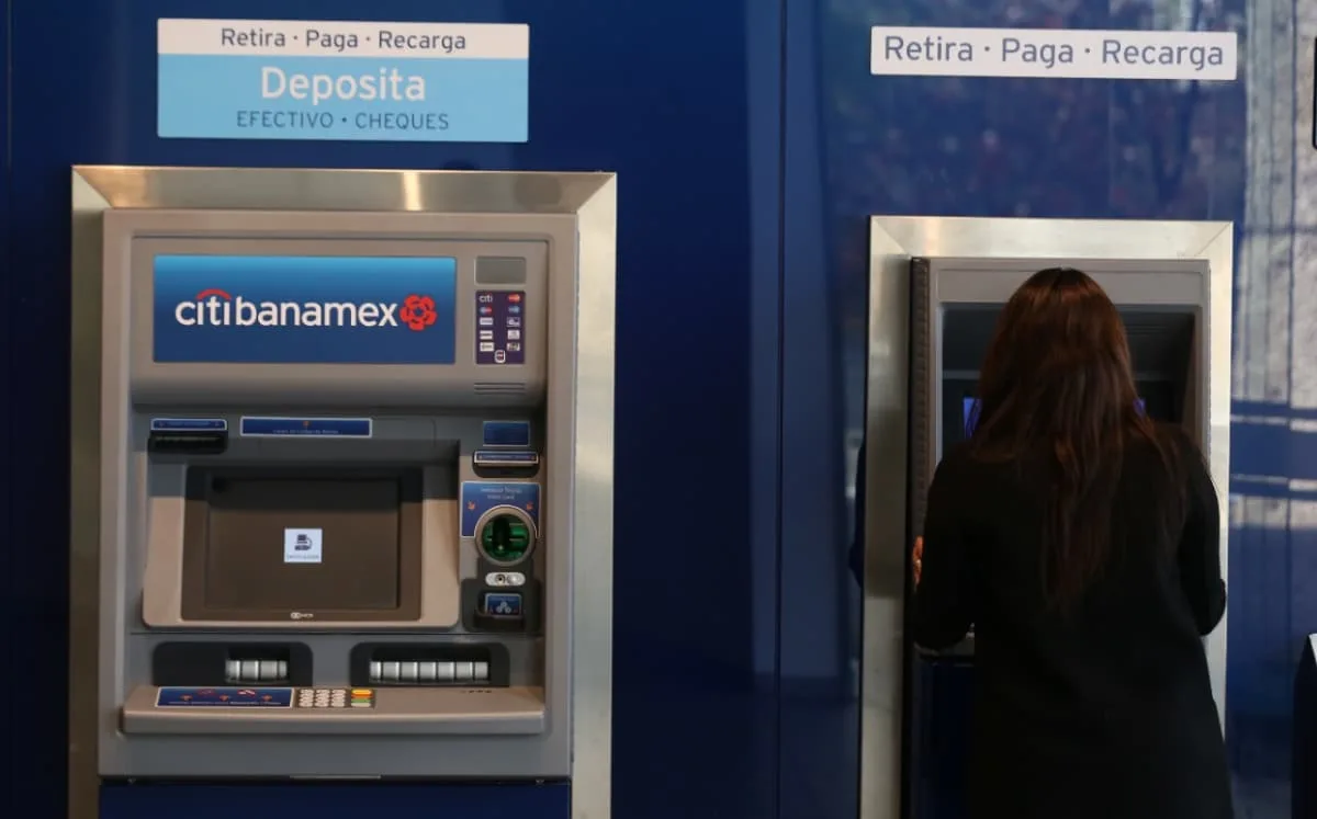 A person using a facial recognition scanner at a bank counter in Mexico