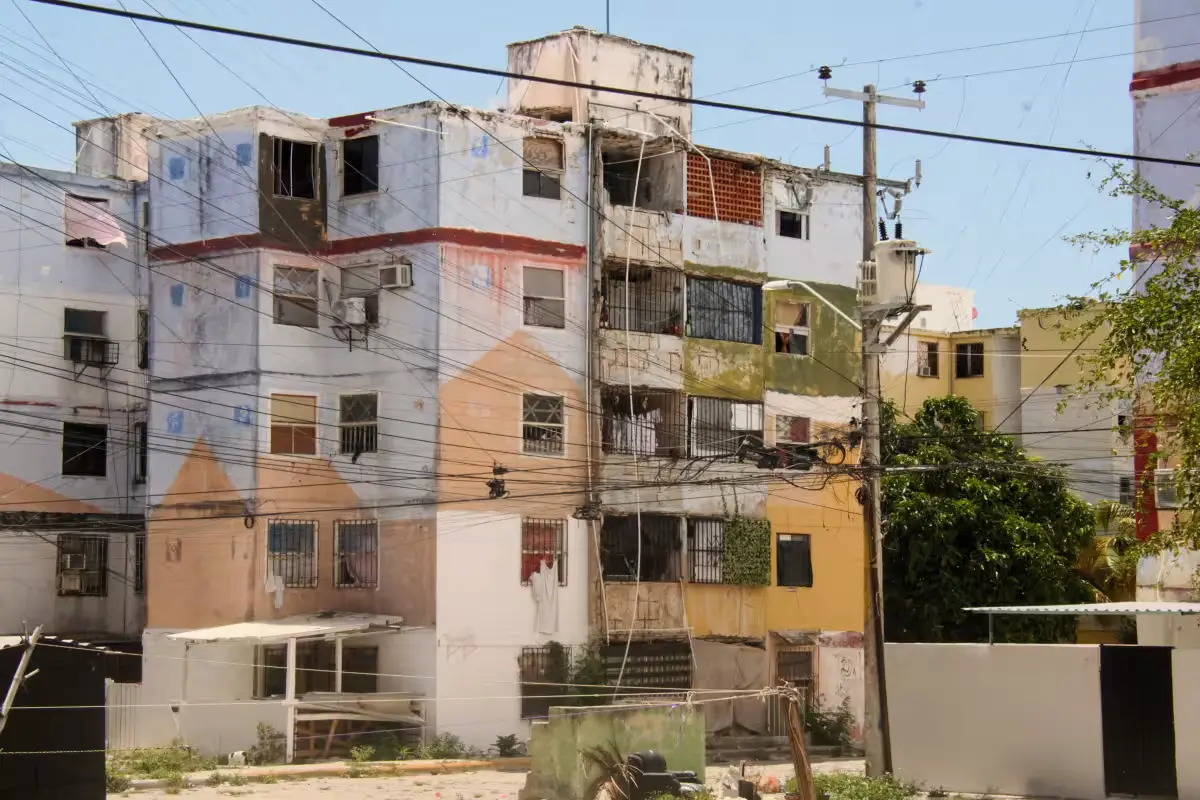 Residents point to moisture stains on a wall in a Cancun housing complex