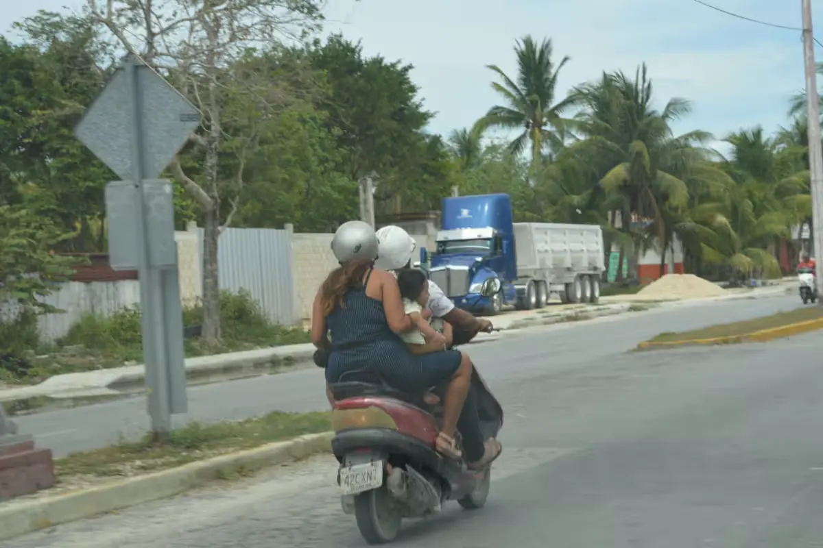 Motorcycles parked along a street in Cozumel, with a traffic accident scene in the background