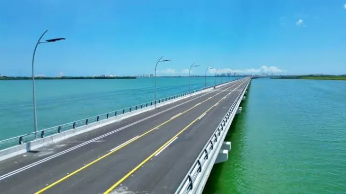 Aerial view of the Nichupte Bridge in Cancun, Quintana Roo, with people cycling and walking on the closed roadway.