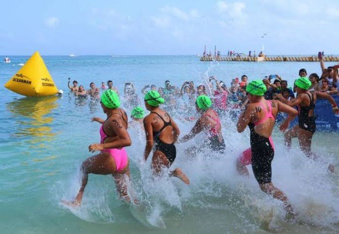 Swimmers compete in the open water at Oceanman Cozumel, featuring races for all ages and skill levels.