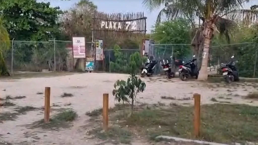 A beach access point at Playa 72 in Playa del Carmen, Quintana Roo, with a fence nearby.