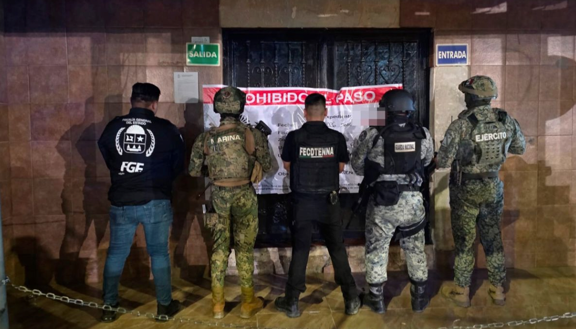 Police officers stand outside a bar in Playa del Carmen where 11 women were found in a human trafficking operation