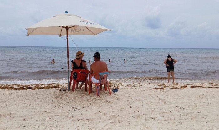 Tourists enjoying a clear beach in Playa del Carmen, Quintana Roo, with no visible sargassum seaweed.
