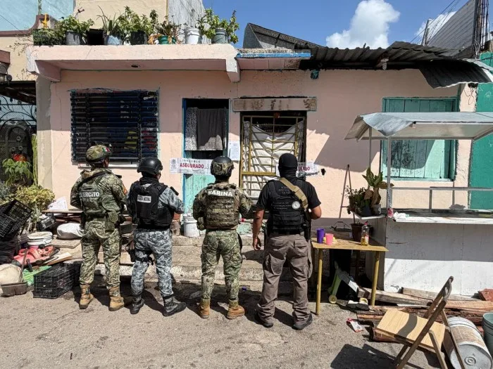 Police officers and military personnel outside a building during a raid in Playa del Carmen