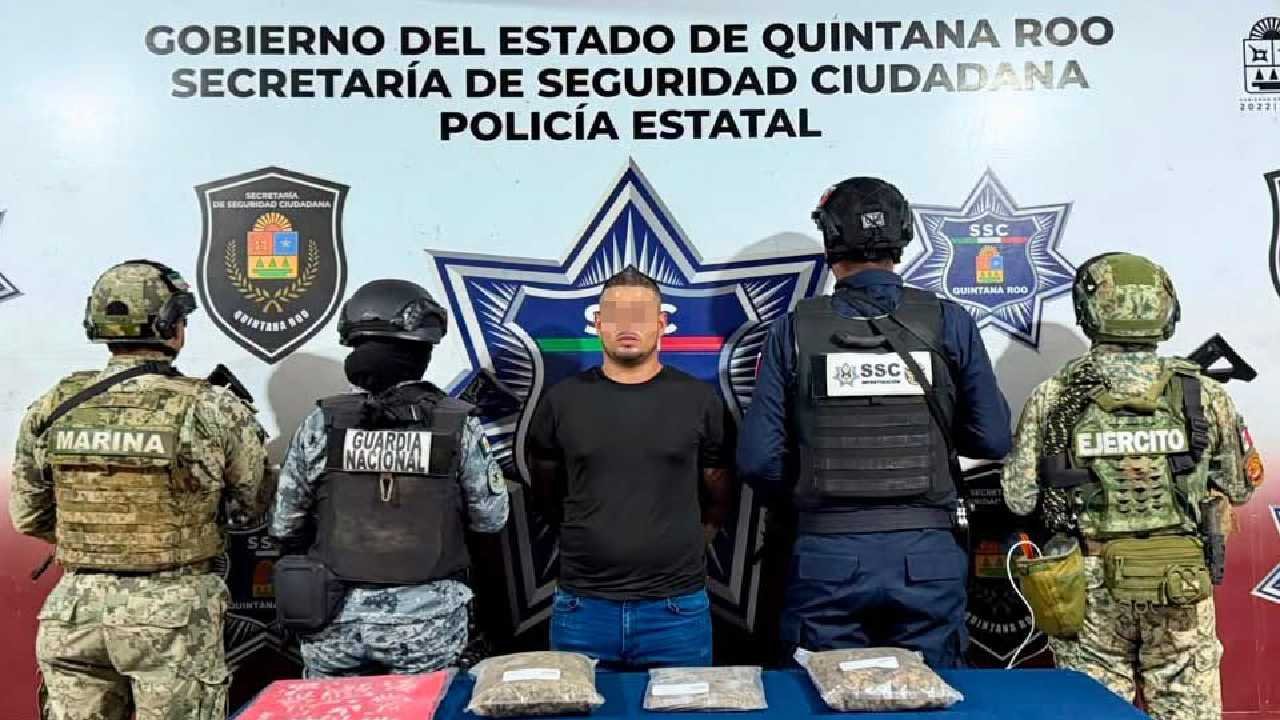 Police officers detain a man next to a white car on a street in Cancun