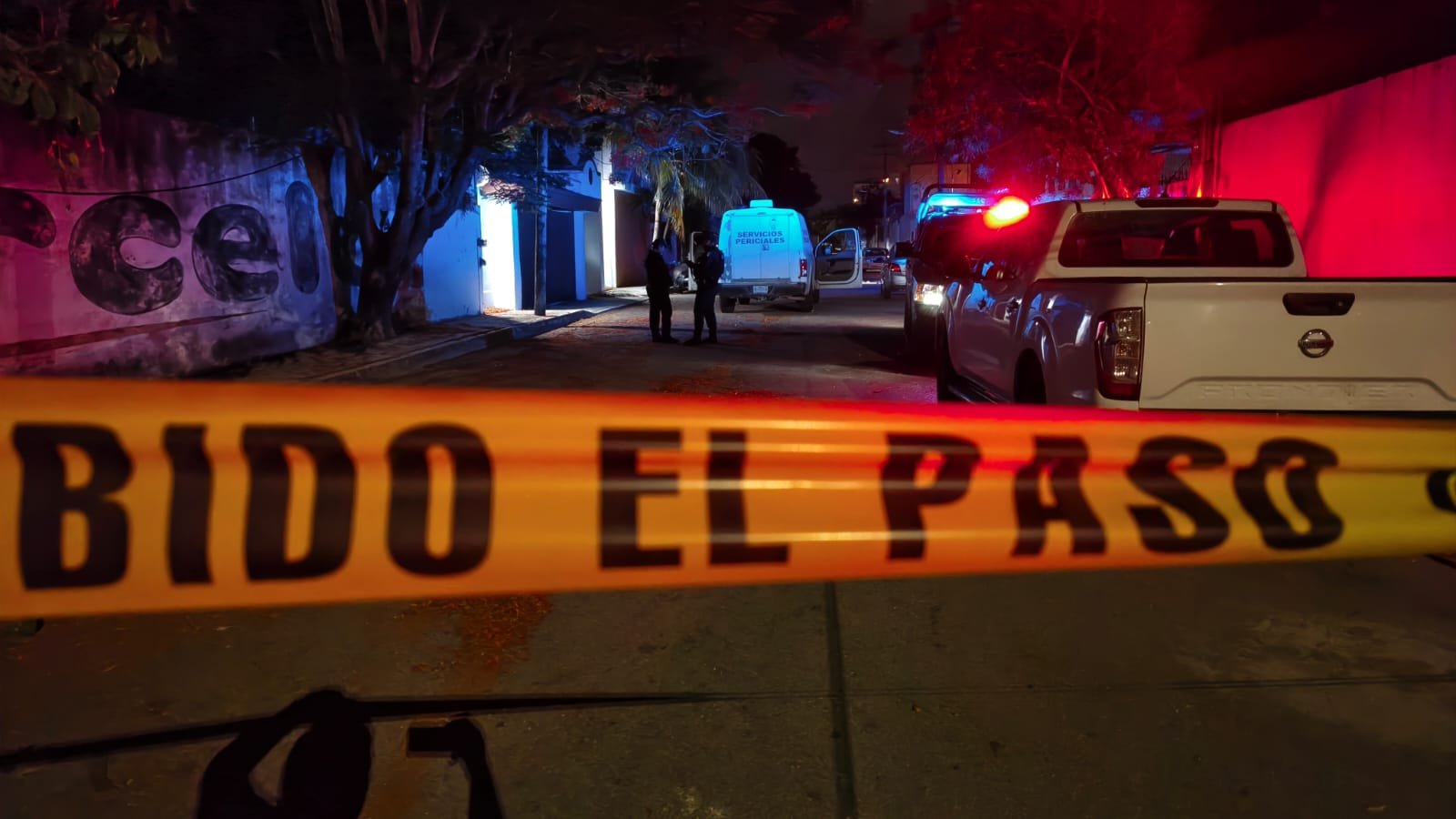 Police officers cordon off the area outside a bar in Playa del Carmen after a shooting