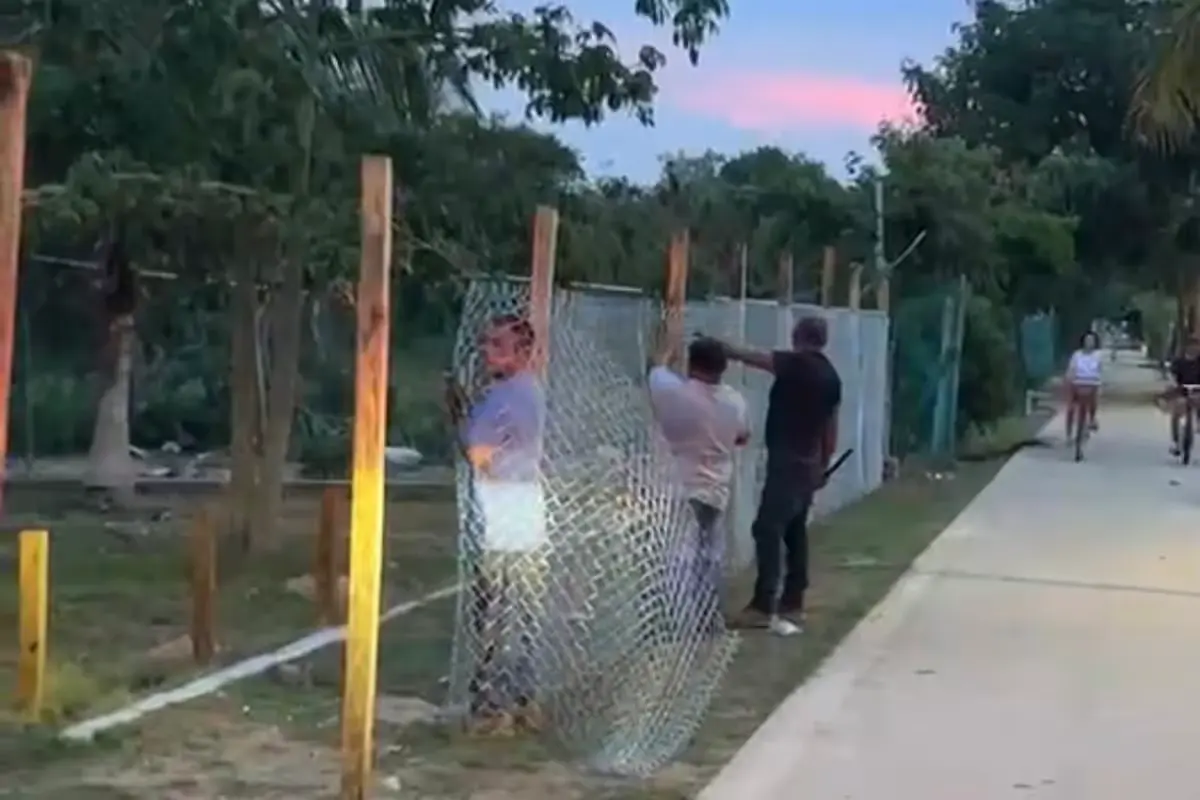 Police officers stand near a fence at Playa 72 in Playa del Carmen as workers attempt to block access.