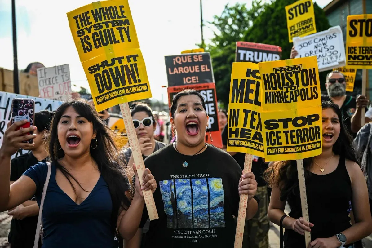 Protesters holding signs in Houston after a Mexican migrant was shot by ICE
