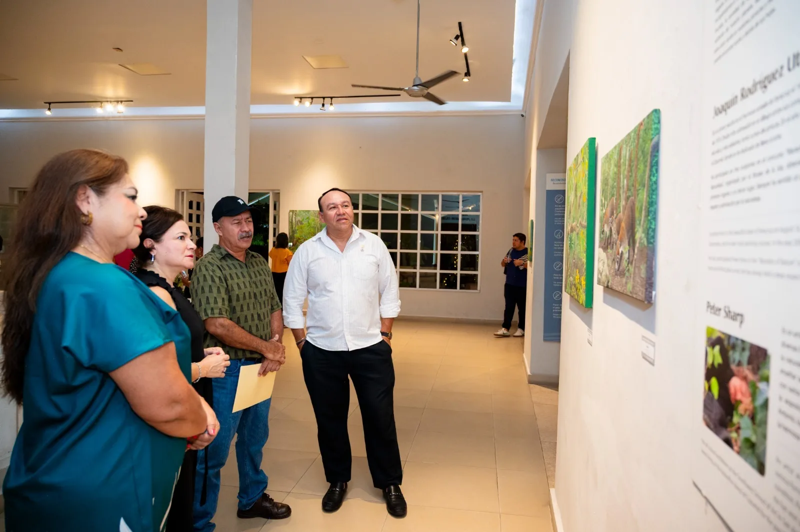 Visitors viewing paintings at the Que Gusto Verde exhibition in Cozumel's Museum of the Island