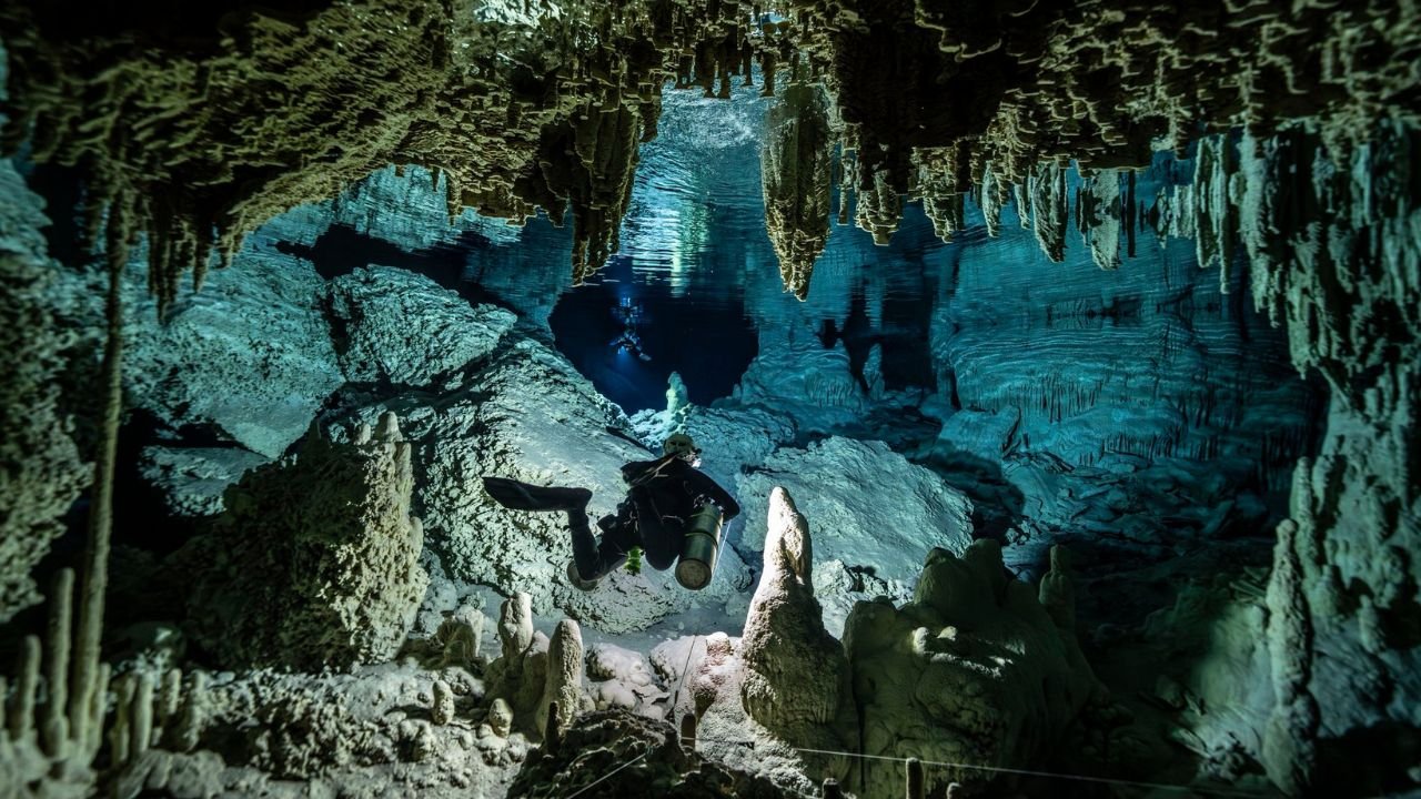Aerial view of the Sac Actun cave system in Quintana Roo, Mexico, showing jungle and cenotes.