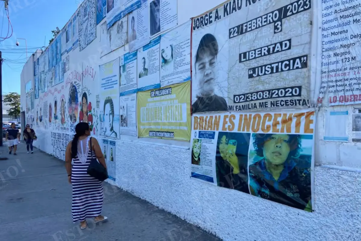 Family members and activists hold up missing-person search cards during a public awareness event in Quintana Roo