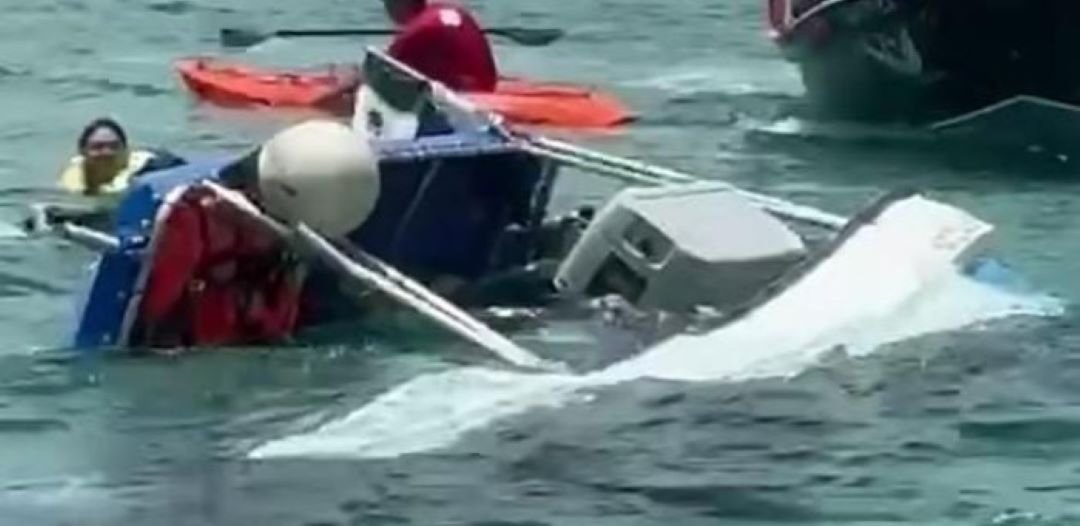 A partially submerged tourist boat named Tea off the coast of Cozumel, with nearby vessels assisting in rescue efforts.