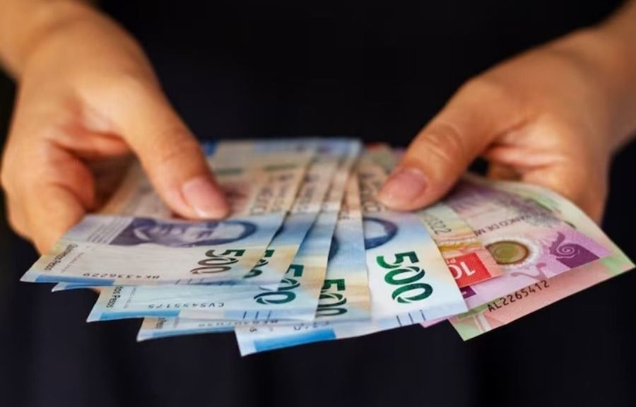 Small business owner shaking hands with official in Chetumal, receiving a zero-interest loan check