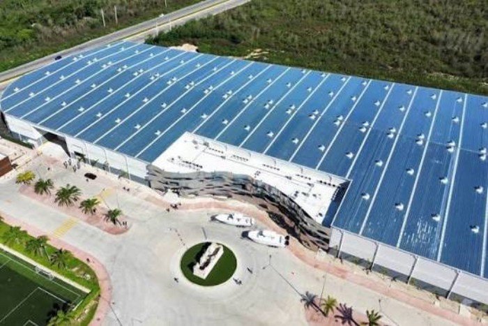 Solar panels installed in a field under a clear blue sky, representing renewable energy.