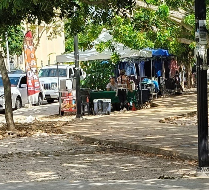 Street vendors selling goods on a sidewalk in Playa del Carmen