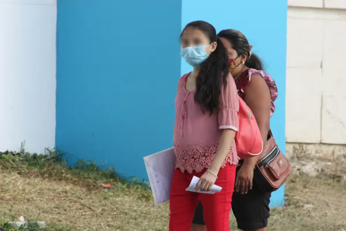A social worker talks with a teenage mother at a DIF office in Cozumel