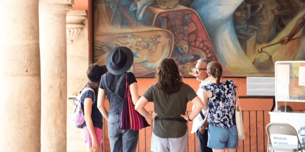 Group of tourists on a free walking tour in Merida's historic center, listening to a guide