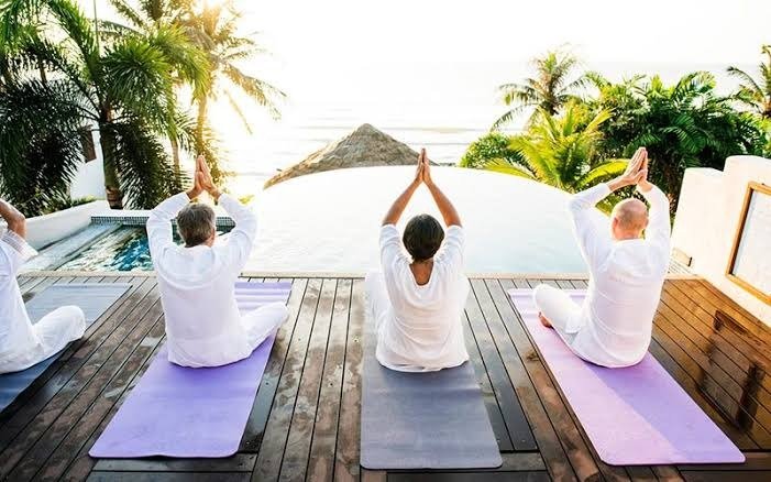 People practicing yoga on a beach in Quintana Roo during a wellness event