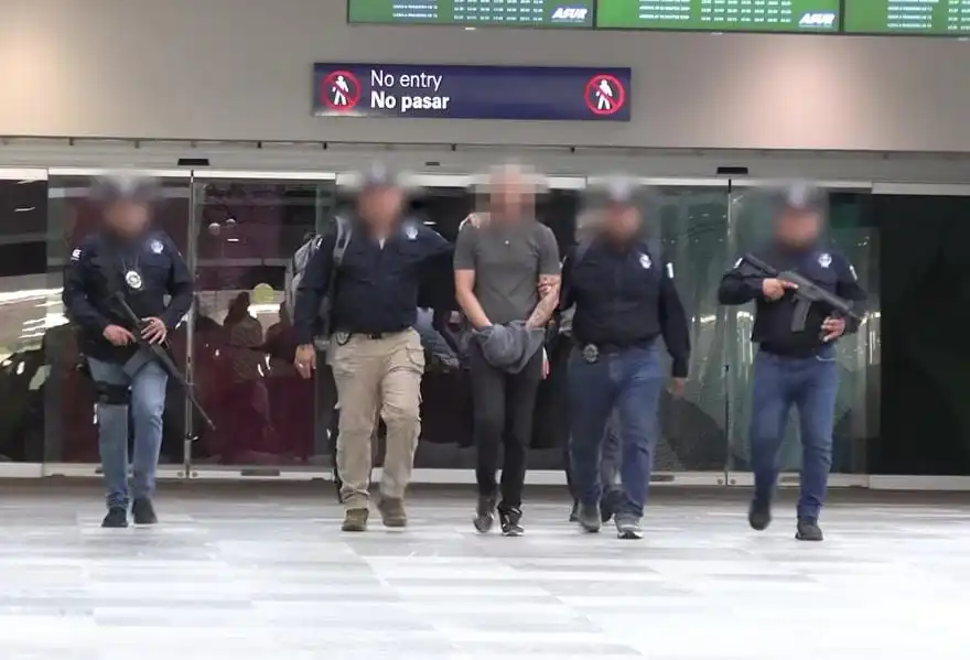 Yadriel N, suspect in the murder of Lizbeth Bustos, being escorted by police officers at Cancun International Airport