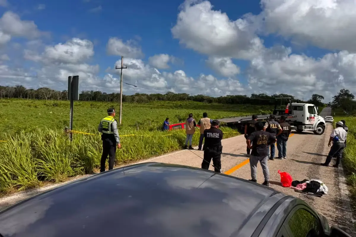 A red Chevrolet lies upside down on a field after a fatal rollover on the Tizimín-Río Lagartos highway in Yucatán, Mexico.