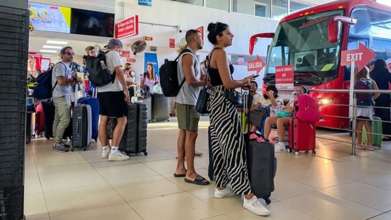 A fleet of ADO buses at Tulum International Airport prepares to carry repatriated Mexican passengers to destinations in central Mexico.