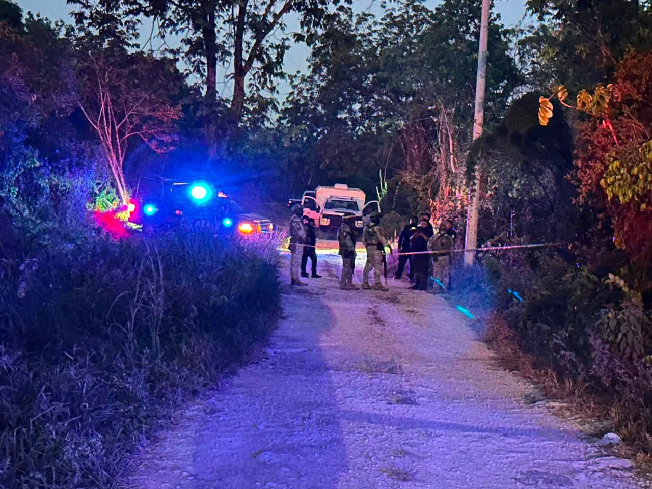 Police officers cordon off a dirt road in Cancun's Carabanchel neighborhood where a body wrapped in blankets was found.