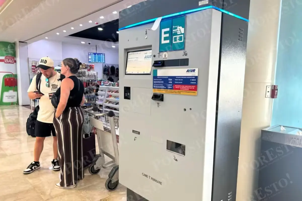 A frustrated traveler at Cancún International Airport trying to use a malfunctioning parking payment machine.