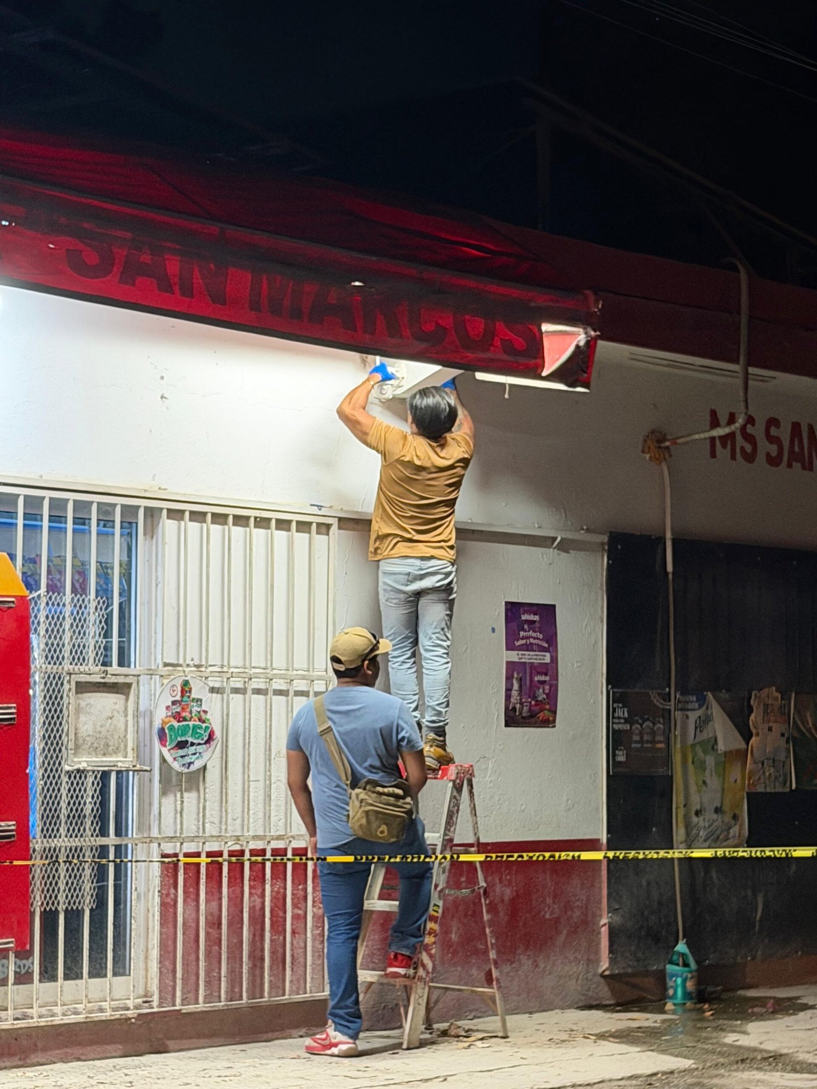 Police officers outside a mini-supermarket in Cancun during a search for security camera footage.