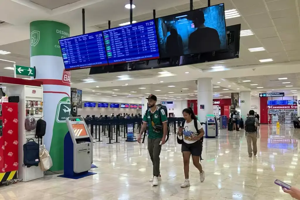 Travelers waiting in line for restrooms at Cancun International Airport