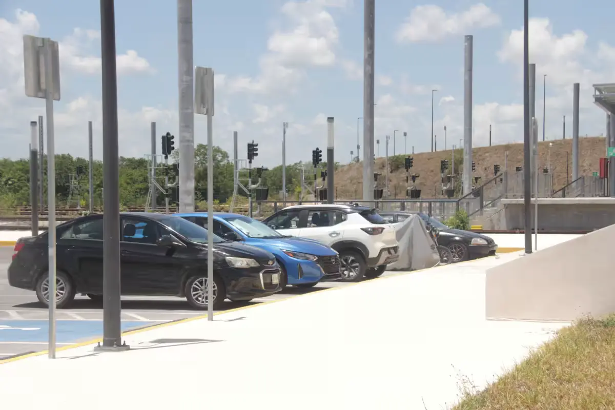 A blue car sits on bricks after having its tires stolen in the Tren Maya station parking lot in Cancún.